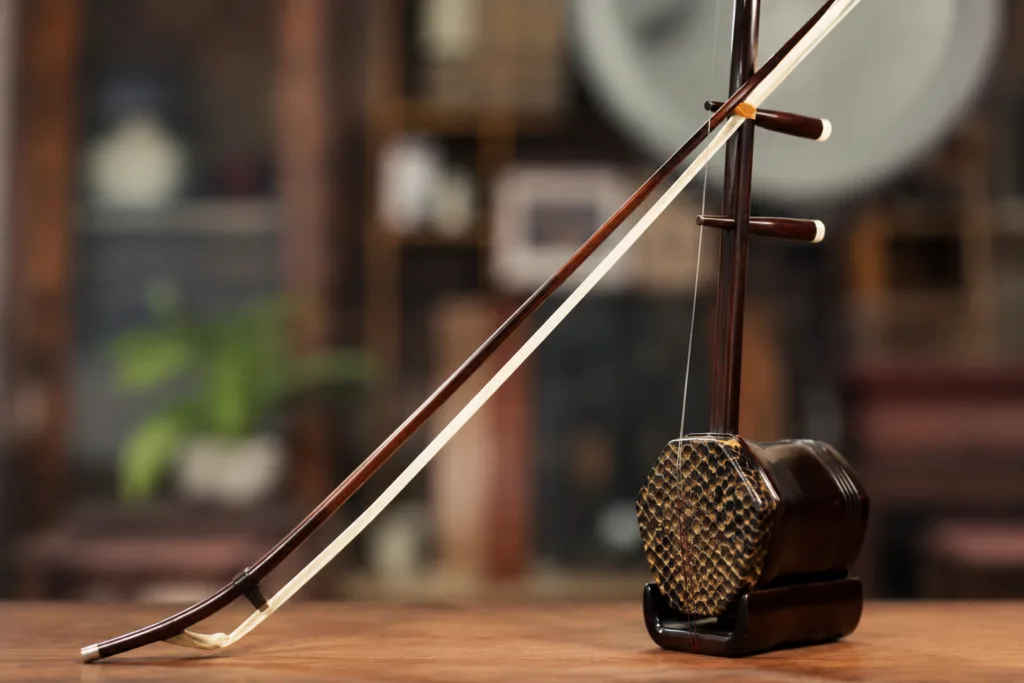 A traditional erhu instrument with two strings and a bow, used to produce expressive Chinese melodies.