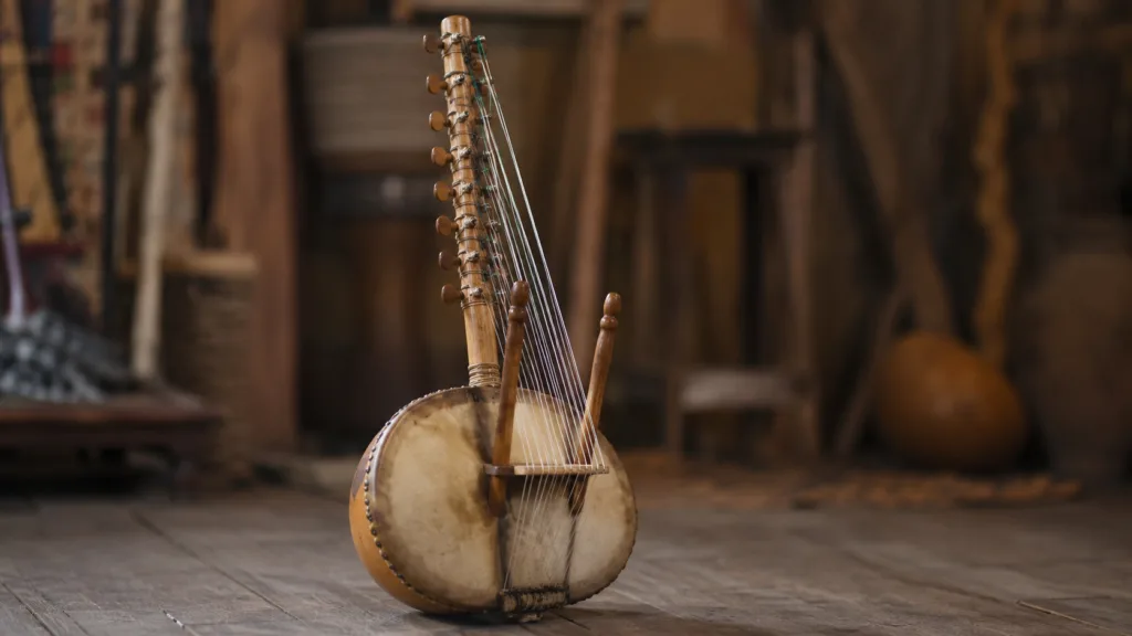 Kora, a traditional West African bridge harp, with a large rounded resonator and intricate wooden neck, played with fingers.