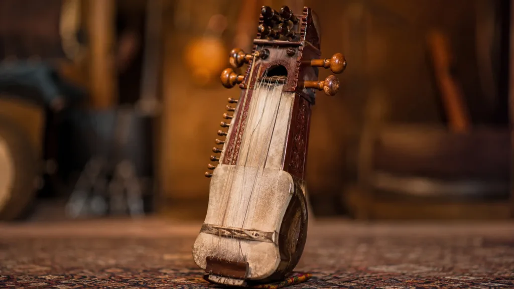 Sarangi instrument with a wooden body and strings, played with a bow to produce traditional South Asian folk music sounds.